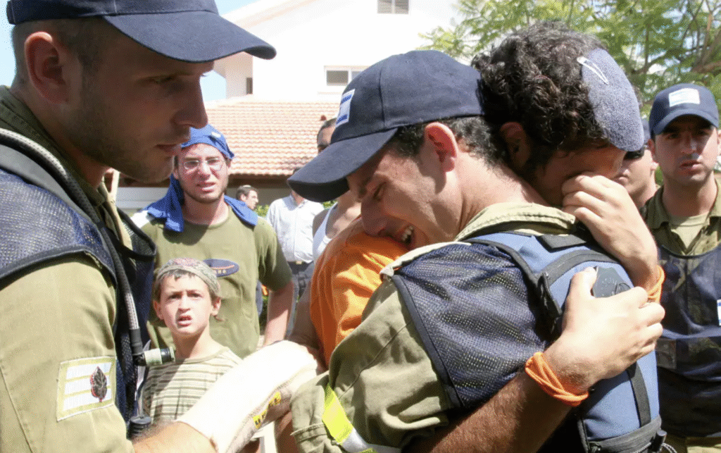 An IDF soldier and a Gush Katif resident cry against the backdrop of the disengagement in 2005 | Archives: Miri Tzachi